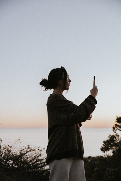 A woman holding a drink while reading a book. Showing that with anxiety therapy in Manhattan you can calm the inner chaos. An anxiety therapist can help you learn to relax and enjoy every day.