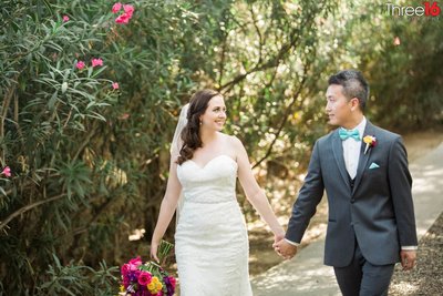 Bride and Groom hold hands while walking at the Jones Victorian Estate wedding venue in Orange, CA