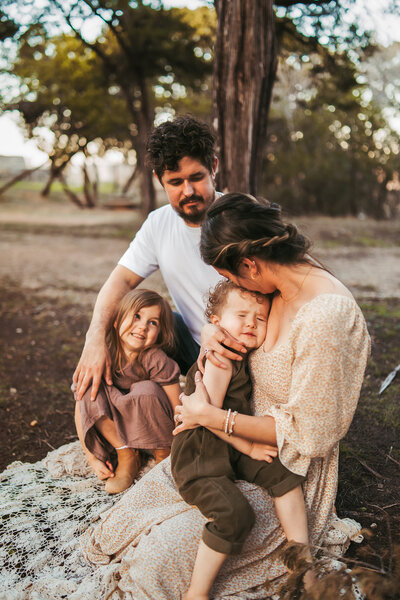Big Bend elopement photographer captures a tender family moment in the desert mountains of West Texas, with golden light, cacti, and rugged peaks framing the scene.