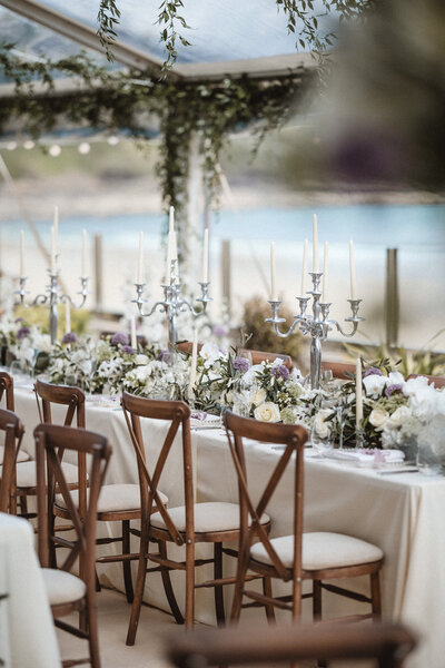 Long banqueting tables of flowers and candelabras for this beach side wedding
