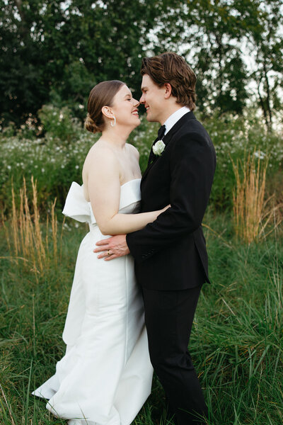 Osage House wedding couple standing in grass outdoors in Cave Springs, Arkansas.