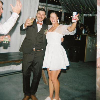 A candid photo of a newlywed couple sharing a joyful moment during their reception.