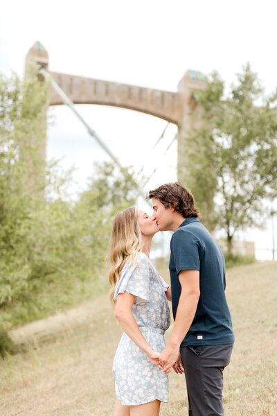 Couple kiss in front of an archway in Downtown Minneapolis.