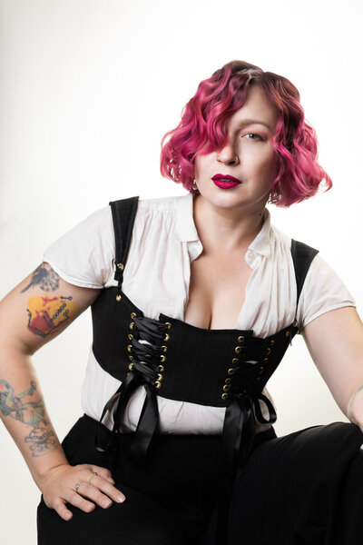 St. Louis boudoir photographer Kelly Cook with Boudie City leans against a ladder with her hand on her hip