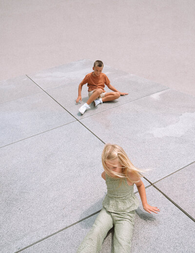 Two kids playing on the concrete at Noguchi Garden in Costa Mesa during a modern family photo session.