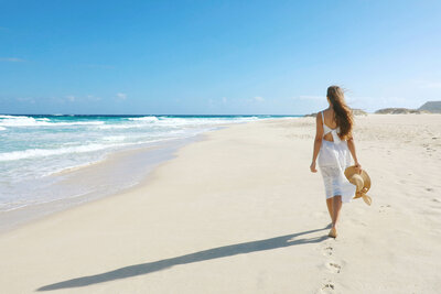 couple walking on the beach holding hands, travel concierge services