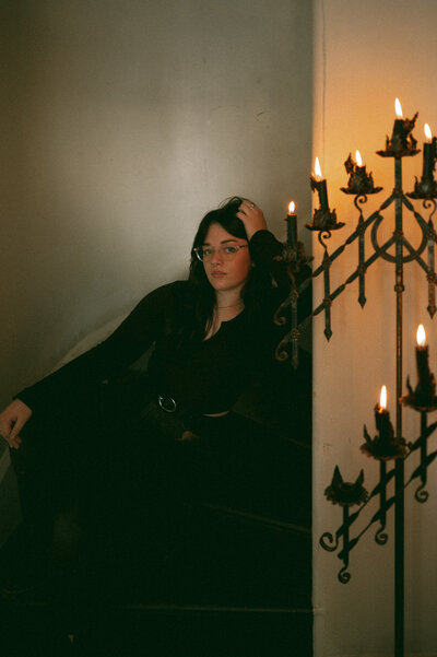 Photographer sitting on stairs with candles around