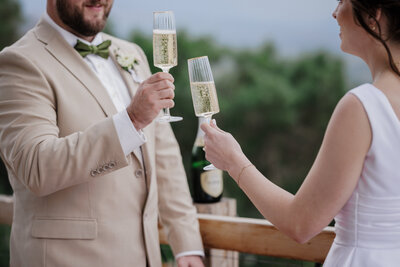 Bride and groom share wedding toast during Airbnb elopement.