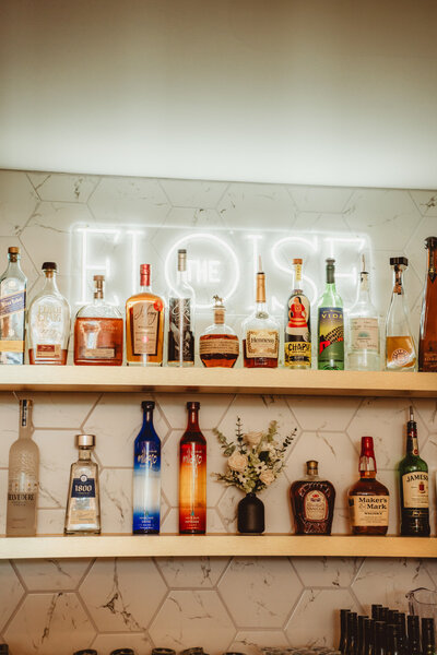 wedding couple posed with wedding cake near bar