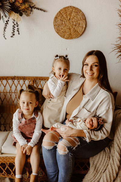 baby girl with her sisters and mom during her lifestyle newborn session in Lincoln, Nebraska