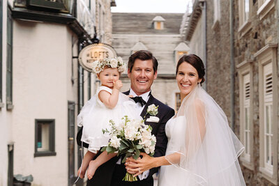 Experience a happy family moment: newlyweds with their little girl wearing flower crowns in Quebec. A perfect American family scene.