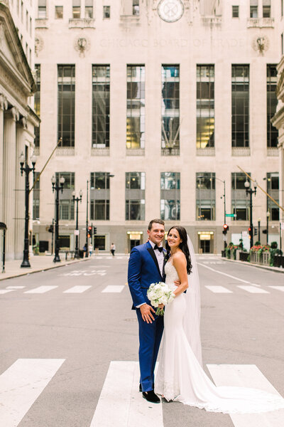 Bride and groom pose in front of the Board of Trade in Chicago.
