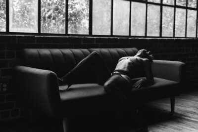 artistic boudoir shot of a woman on couch leaning back