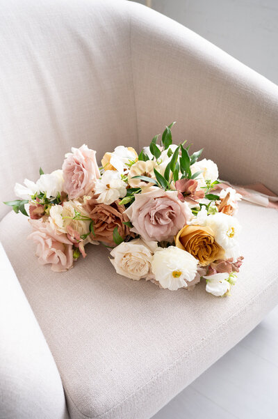 A bouquet of pink, caramel and white roses resting on a couch in Atlanta, GA