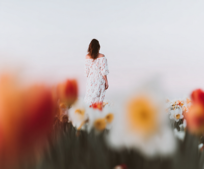 Confident woman with short black hair and bold red lips wearing an open white shirt, embodying brand alchemy, magnetic presence, and the power of transformation through language and image.