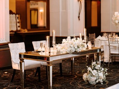 Rustic-chic wedding table decor with vibrant floral centerpieces and natural greenery, crafted by Leigh Florist