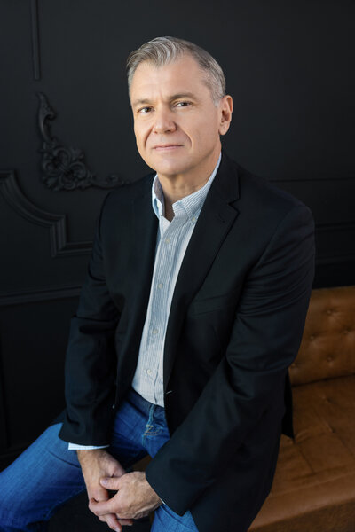 Man sitting for headshot in a chair
