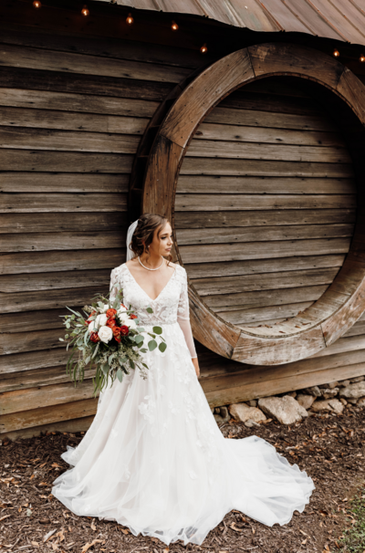 bride holding bouquet standing outside of venue