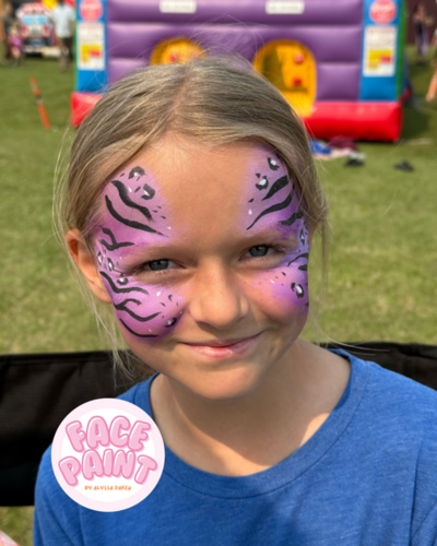Young girl with purple tiger and cheetah print face paint at a bemidji county fair