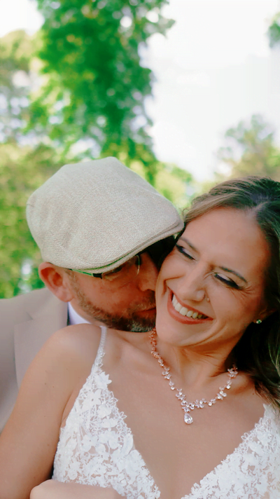 Bride and groom walking down the aisle outdoors with trees behind them