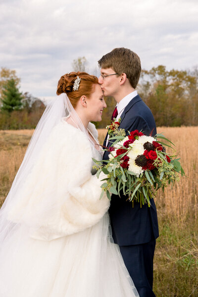 Groom kissing bride on the head at Nashville wedding