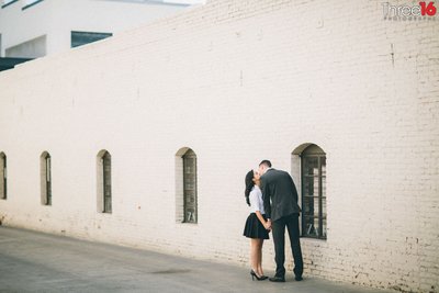 Engaged couple share a romantic kiss in an alleyway in Old Pasadena
