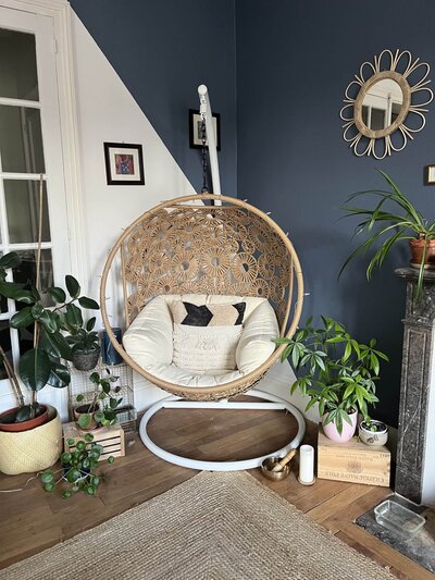 Chaise détente et mur bleu avec plantes vertes chez Julie Blanvillain