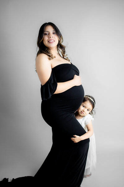Pregnant woman with first born daughter  during a maternity photoshoot