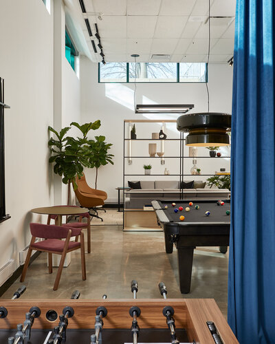 A vibrant lounge featuring foosball and pool tables and elegantly  decorated seating areas