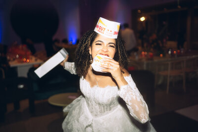 Flash photo of bride eating In N Out on the dance floor at wedding planned by Bloom & Blueprint