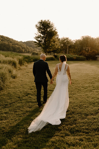 Married couple walking at sunset at New York barn wedding venue