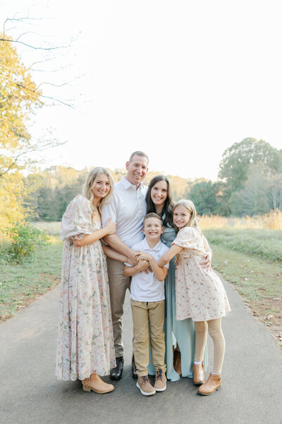 Family snuggled together standing on a path