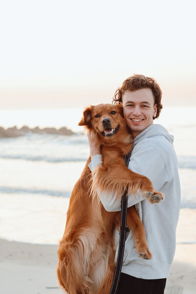 Man holding a golden retriever on Folly Beach, South Carolina