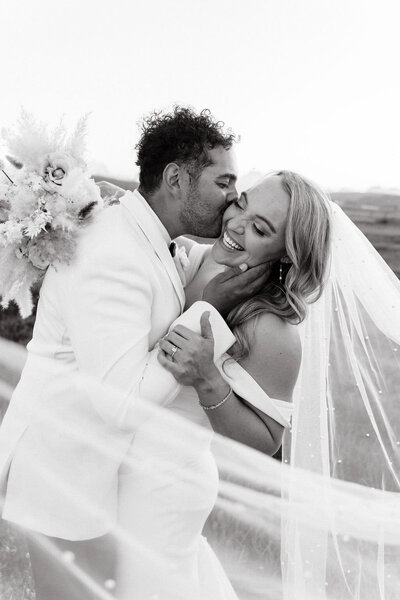 photo of bride and groom embracing and smiling taken by Wyoming wedding photographer