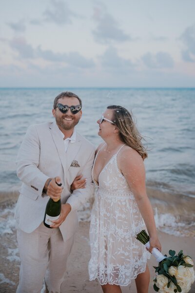 Destination wedding photographers captures bride and groom popping champagne