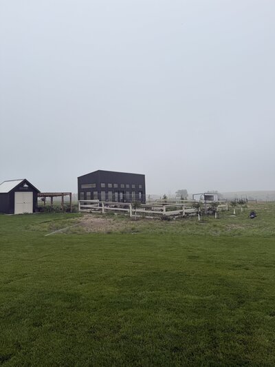foggy morning view of the family farmhouse and fenced pasture in rural Kansas

