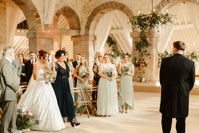 Bride and bridesmaids laughing under confetti at aswanley wedding venue