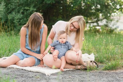 Family with baby on picnic blanket