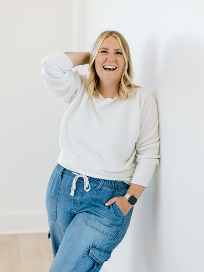 woman poses against white wall