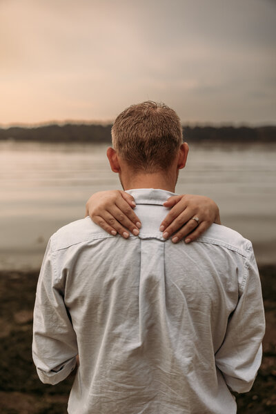 guy is bear hugging his girl and kissing her cheek