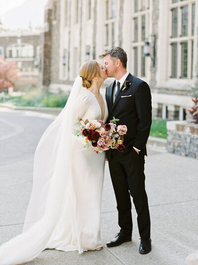 Elegant and timeless wedding inspiration, stunning couple in front of the Fairmont Banff Springs Hotel, captured by Justine Milton Photography, wedding photographer & videographer in Calgary Alberta. Featured on the Bronte Bride Vendor Guide.
