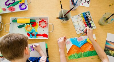 Children painting on a wooden table