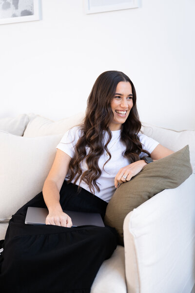 NZ Xero certified Bookkeeper sitting on couch looking away