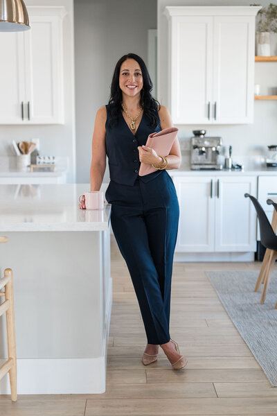 saleswoman wearing business suit holding coffee and planner