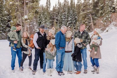 A happy extended family has a good time while exploring a snowy forest together