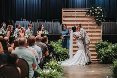 Bride and groom smiling as they walk down a street with their white bouquet of flowers.