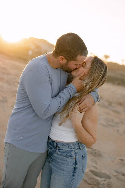Couple kissing on beach by Orlando engagement photographer, Marissa Nicole