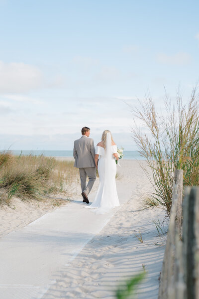 Bride and groom walking on the beach after their New Jersey wedding ceremony.