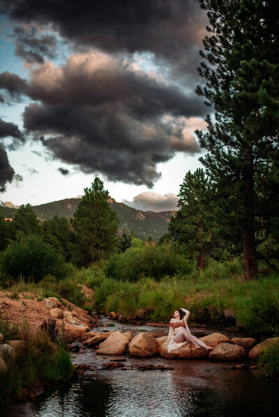 A pregnant mama enjoys a moment by the River in Estes Park 