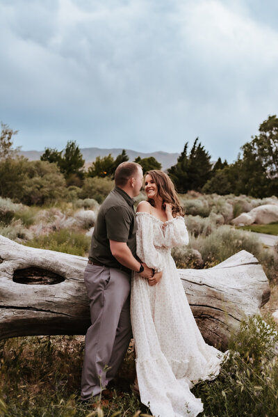 A wife looking back and smiling at her husband who is embracing her at Crystal Peak Park.
